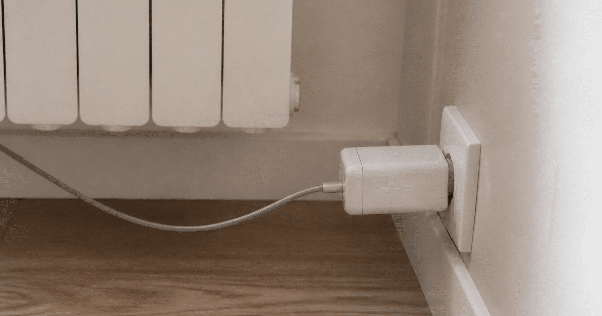 Adaptateur électrique blanc inséré horizontalement dans prise radiateur murale