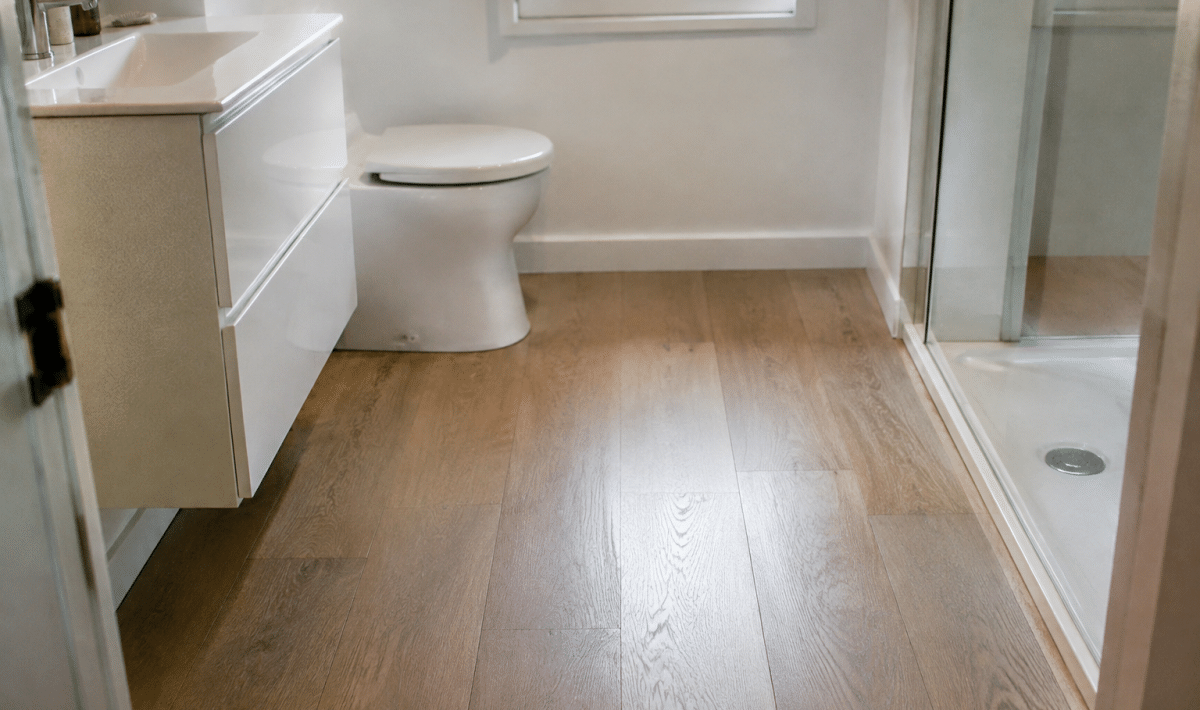 Plancher bois clair recouvrant sol salle bain blanche
