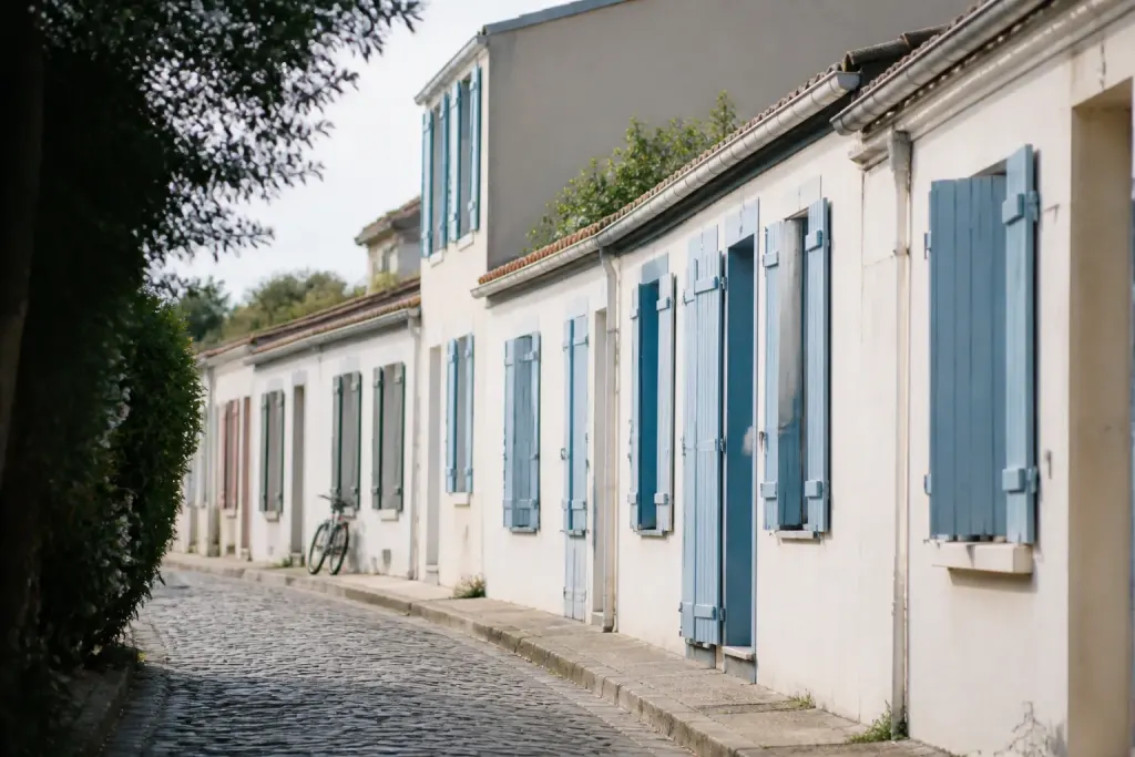 Rue pavee bordee de maisons basses et volets bleus
