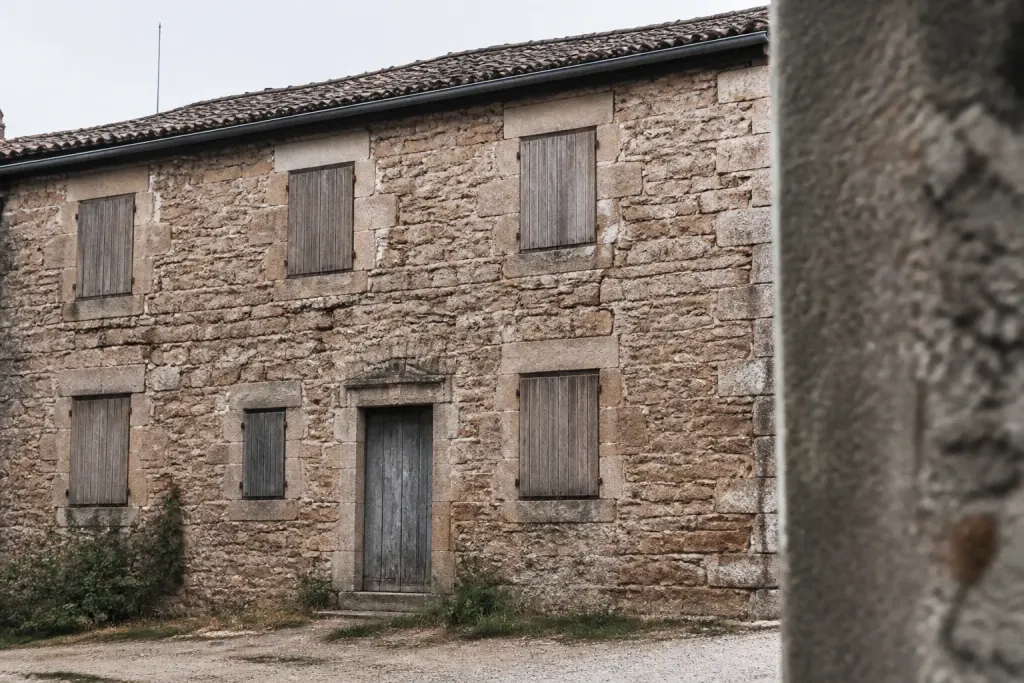Vieil immeuble en pierre aux volets clos